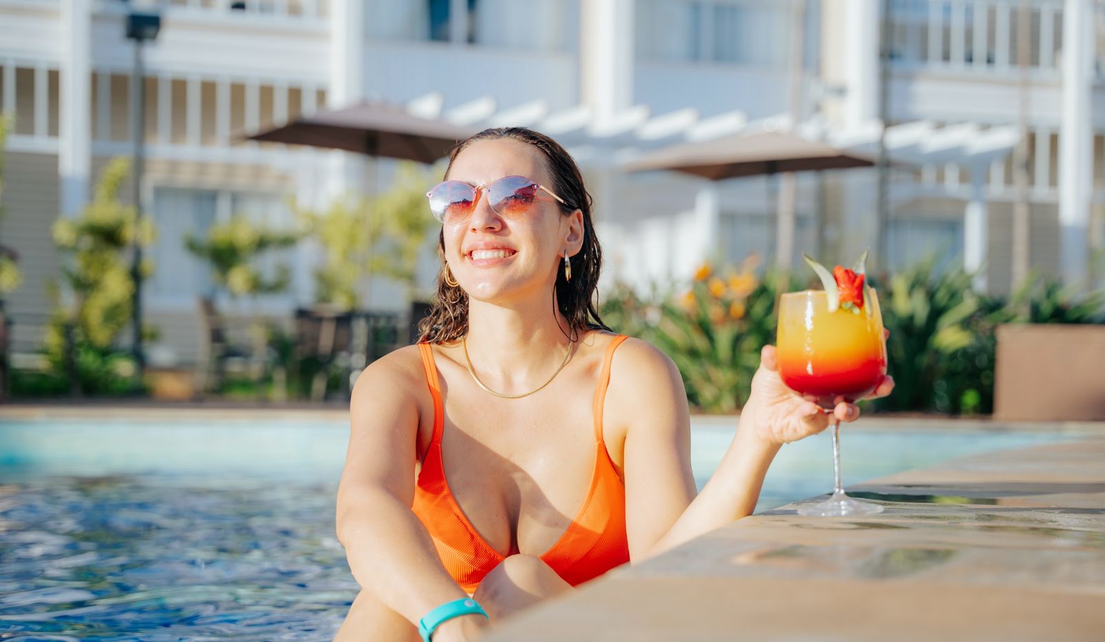 Hóspede relaxando na piscina do resort com drink